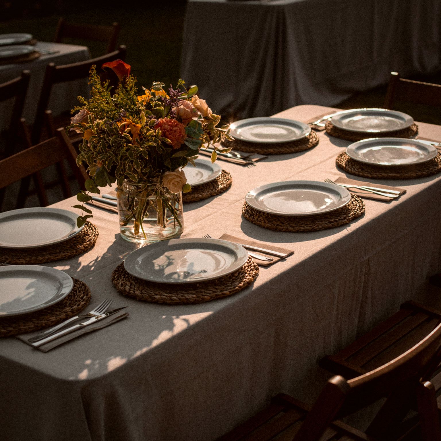 Mesa de gala montada con vajilla, mantelería y centro floral