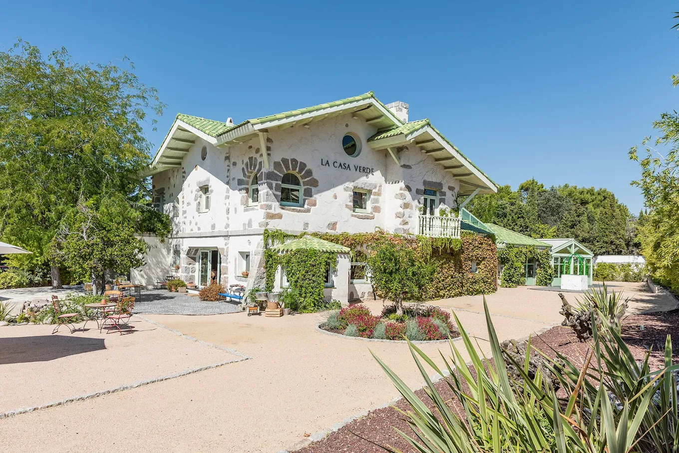 La Casa Verde, fachada de piedra con tejado verde y jardín, Torrelodones