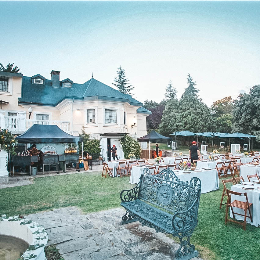 Finca al atardecer con estaciones de asado y mesas montadas