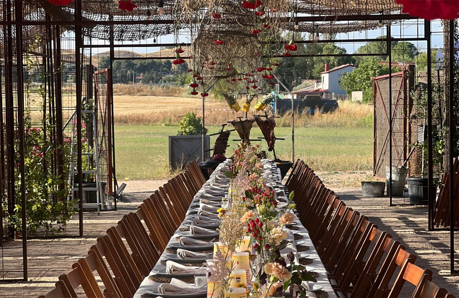 Mesa larga compartida montada al aire libre con flores