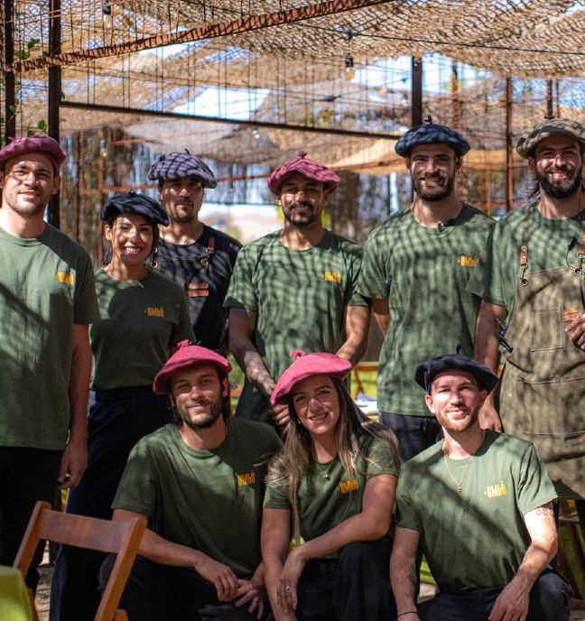 El equipo de El Ombú con sus boinas y camisetas verdes, posando bajo el toldo de un evento